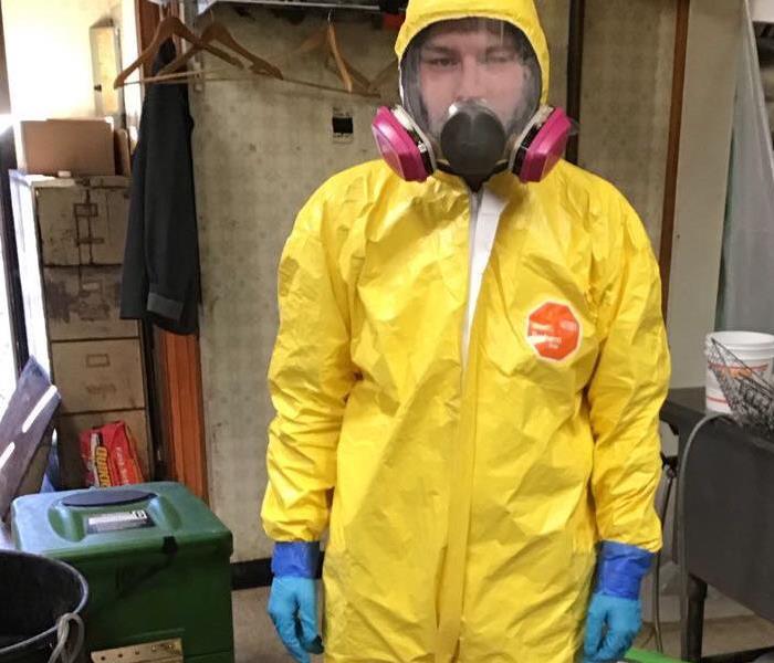 Man wearing full body PPE, full face mask, booties, gloves 